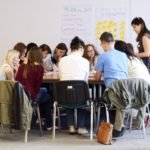 grupa osób siedzących wspólnie przy stole nad projektem