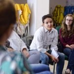 kobieta prowadzi rozmowę siedząc na krześle