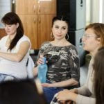 kobieta z butelką w ręku patrzy na inną kobietę