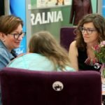 trzy kobiety prowadzą rozmowę siedząc na krzesłach