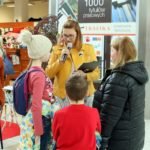 kobieta z mikrofonem mówi do dzieci