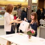 kobieta wręcza dziecku upominek