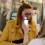 kobieta przykłada telefon do twarzy innej kobiety