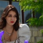 Młoda kobieta z balonikiem w ręku spogląda w dal zamyślona. Wygląda jakby nie dawno płakała.