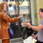 Na pierwszym planie dziewczyna ofiarowuje fiolkę z płynem chłopakowi. W tle chłopak i dziewczyna przyglądają się temu.