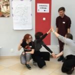 dwie kucające osoby trzymają się za ręce